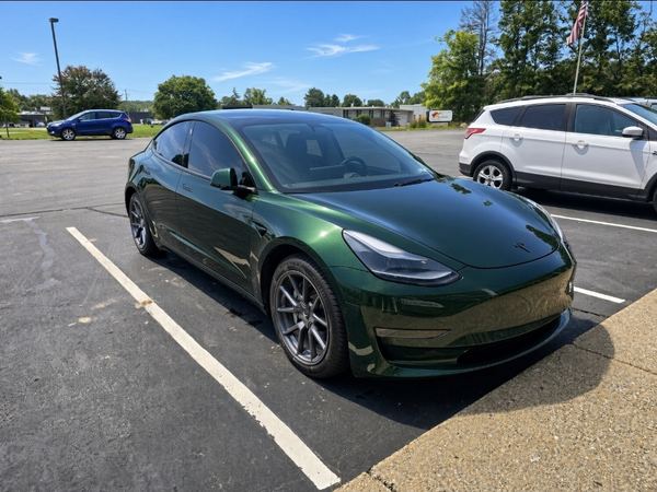 Tesla Model 3 in a gloss dark green color-change wrap